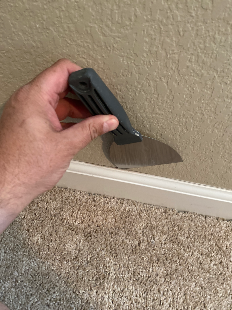 Using a putty knife to remove trim