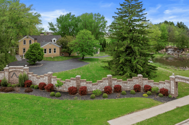 A stone fence between the sidewalk and the property